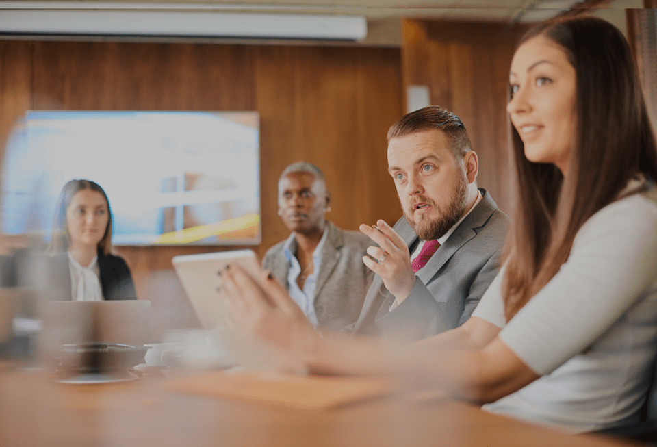 A group of business people talking around a table.